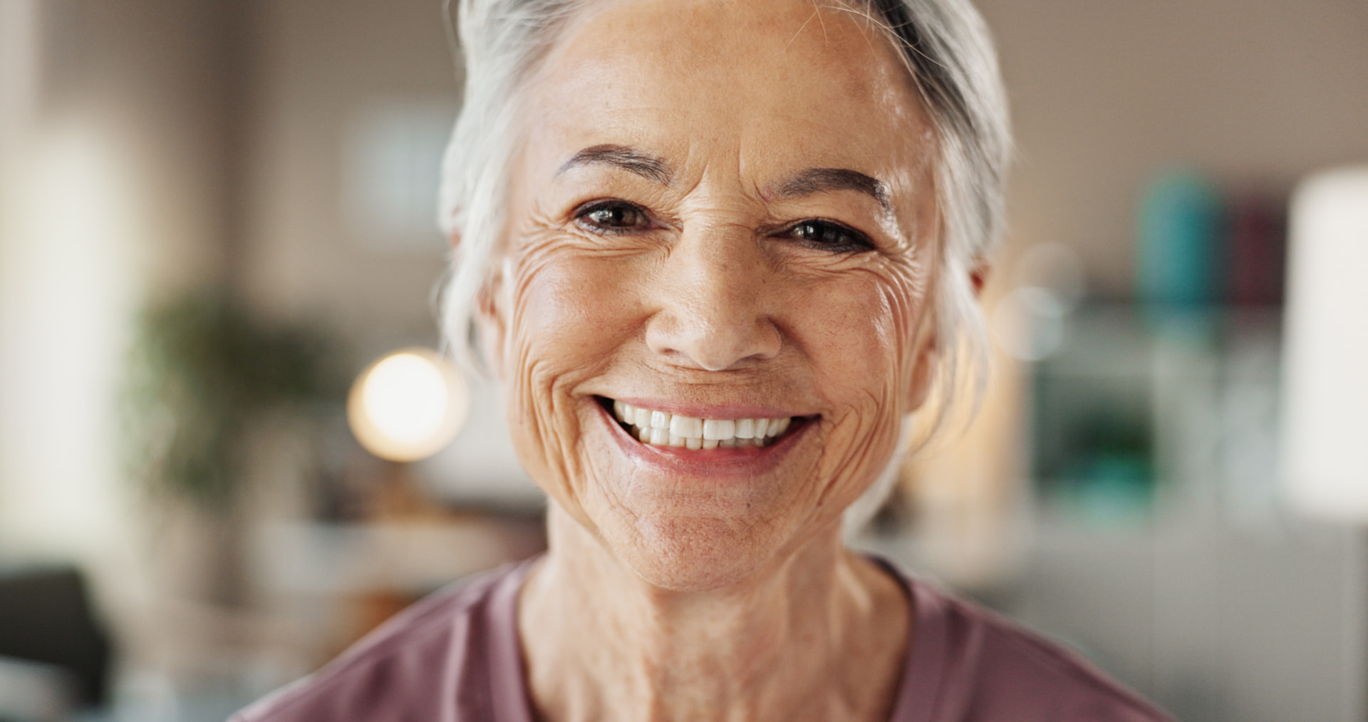Senhora sorrindo em um ambiente acolhedor